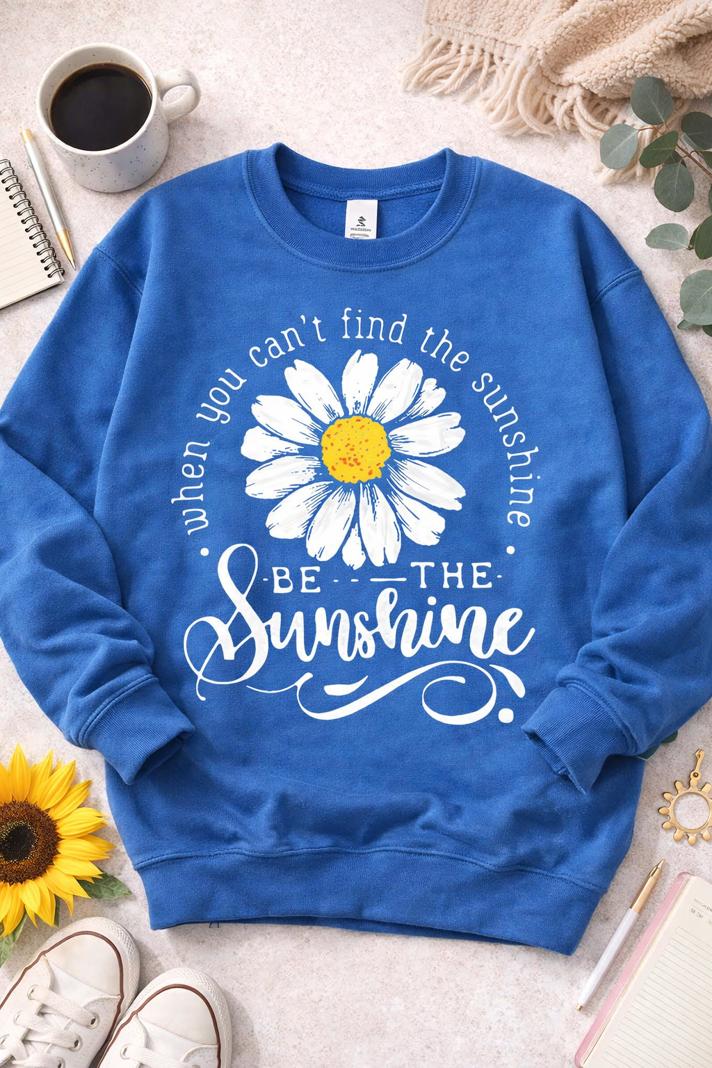Blue sweatshirt with daisy graphic and be the sunshine phrase